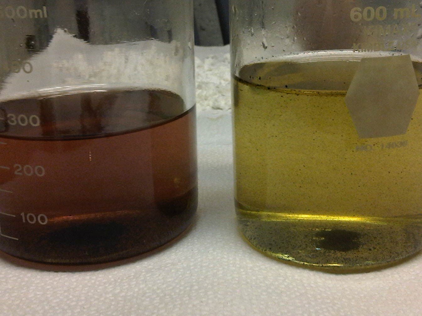 Before/after beakers — dark produced water clarified to clear yellow.