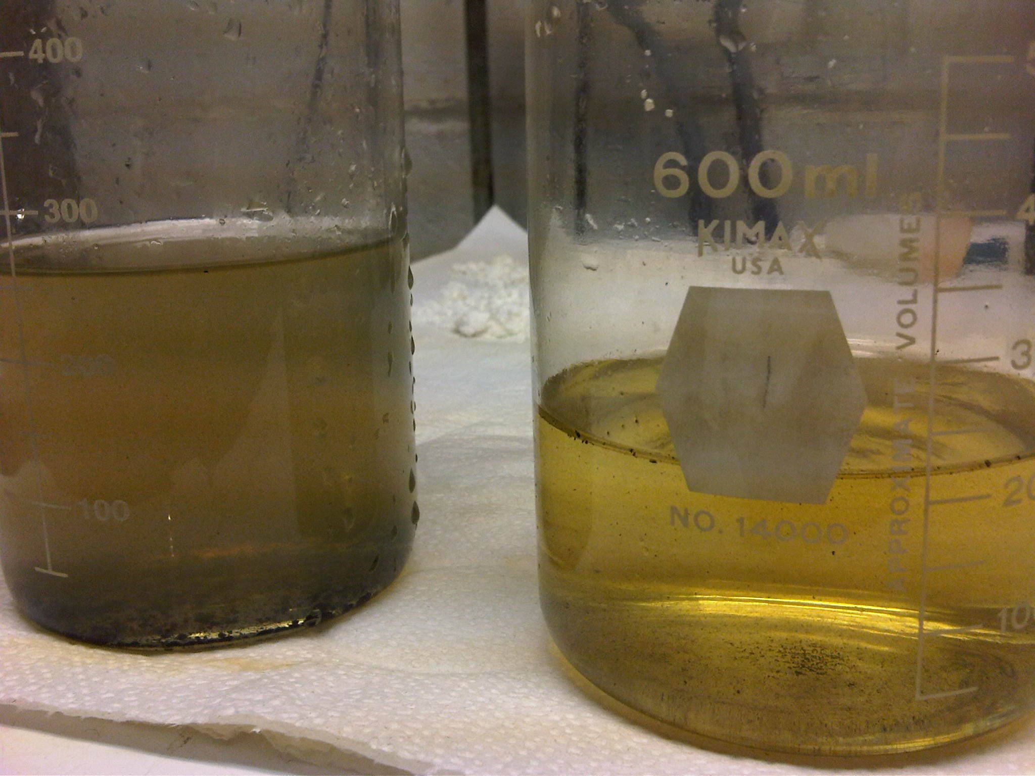 Bench comparison of scale-prone produced water before and after inhibitor treatment.